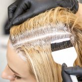 hairdresser-dyeing-blonde-hair-roots-with-brush-young-woman-hair-salon_Easy-Resize.com