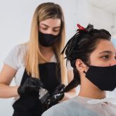 hairdresser-with-face-mask-and-gloves-applying-dye-to-client_Easy-Resize.com