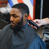 portrait-of-young-black-man-being-trimmed-with-professional-electric-clipper-machine_Easy-Resize.com